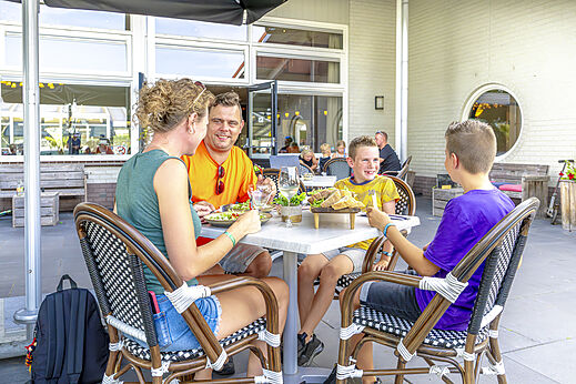 Familie isst auf der Restaurantterrasse von Camping CAPFUN De Fruithof in Klijndijk.