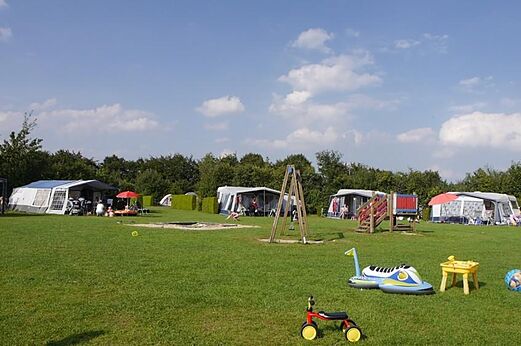 Rasenstellplatz mit Spielplatz und Zelten auf dem Campingplatz CAPFUN De Fruithof in Klijndijk.
