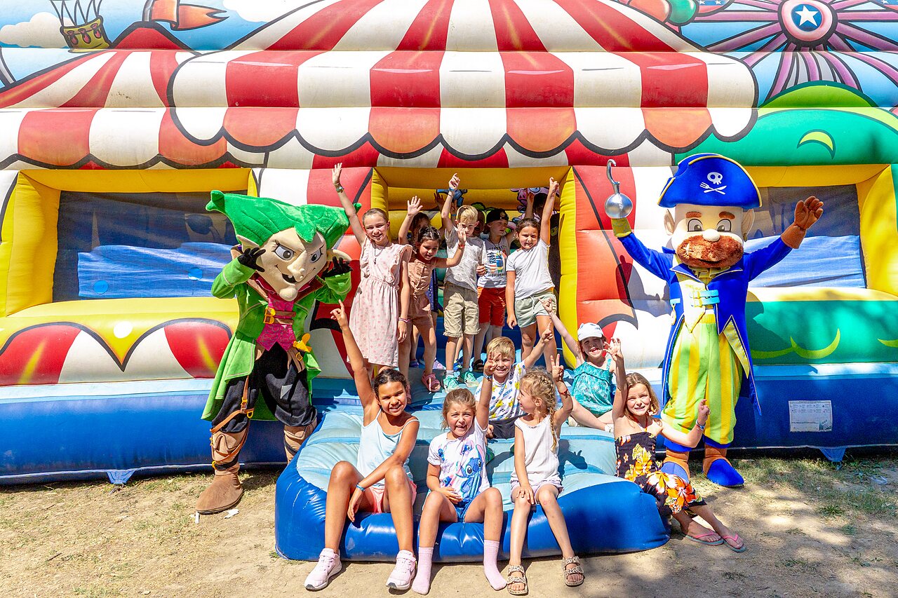 Enfants et mascottes devant un ch�teau gonflable au camping CAPFUN Fumades � ALLEGRE-LES-FUMADES.