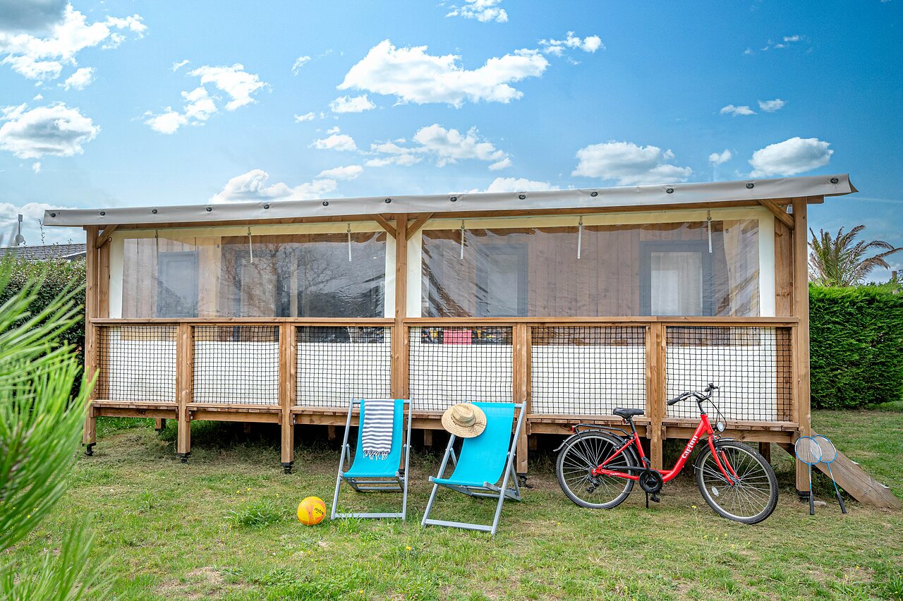 Glamping-Lodge, Liegest�hle, Fahrrad auf dem Campingplatz CAPFUN Golf in SAINT JEAN DE LA RIVIERE (50).