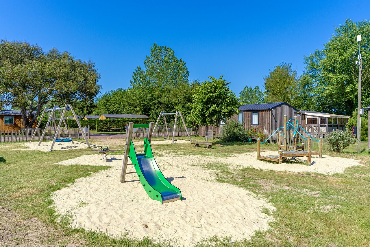 Spielplatz mit Rutsche und Schaukeln auf dem Campingplatz CAPFUN Golf, SAINT JEAN DE LA RIVIERE (50).