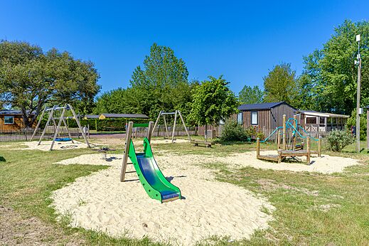 Speeltuin met glijbaan en schommels op camping CAPFUN Golf, SAINT JEAN DE LA RIVIERE (50).
