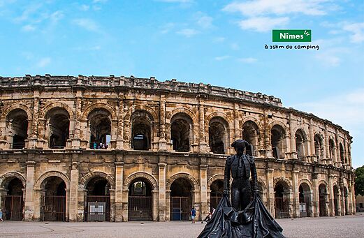 Romeinse arena van Nîmes en stiervechterbeeld, bezienswaardigheid nabij de camping.