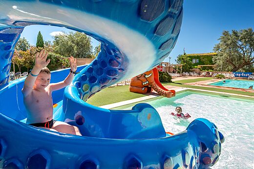 Kind auf blauer Wasserrutsche und Pool auf dem Campingplatz CAPFUN Grande Cosse in Saint Pierre la Mer (11).