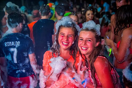 Twee lachende meisjes genieten van een bruisend schuimfeest op camping CAPFUN Grand Cerf in Gimouille (58).