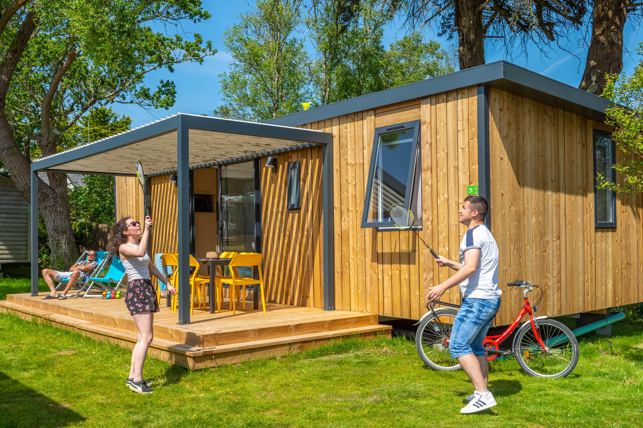 Modernes Mobilheim, Paar spielt Badminton, Terrasse auf Camping CAPFUN Grand Large in FOUESNANT.