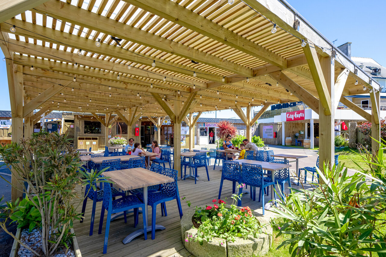 Schattige Restaurantterrasse, blaue Tische, Camping CAPFUN Grand Large FOUESNANT (29).