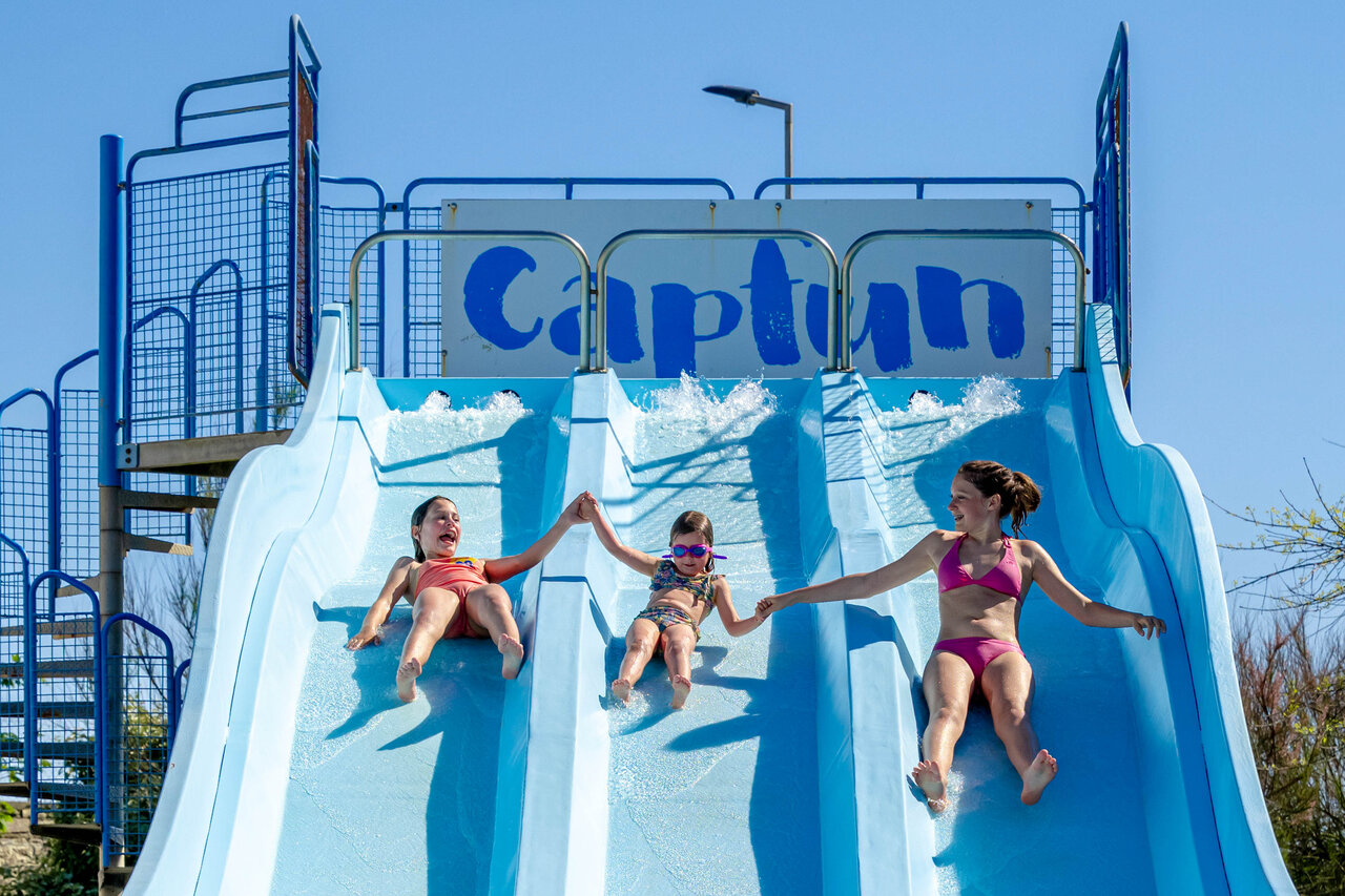Kinder rutschen mehrspurige Wasserrutsche hinunter auf Camping CAPFUN Grand Large in FOUESNANT (29).