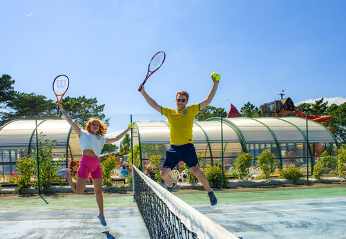 Tennisplatz und springende Spieler auf dem Campingplatz CAPFUN Grand Large in FOUESNANT (29).