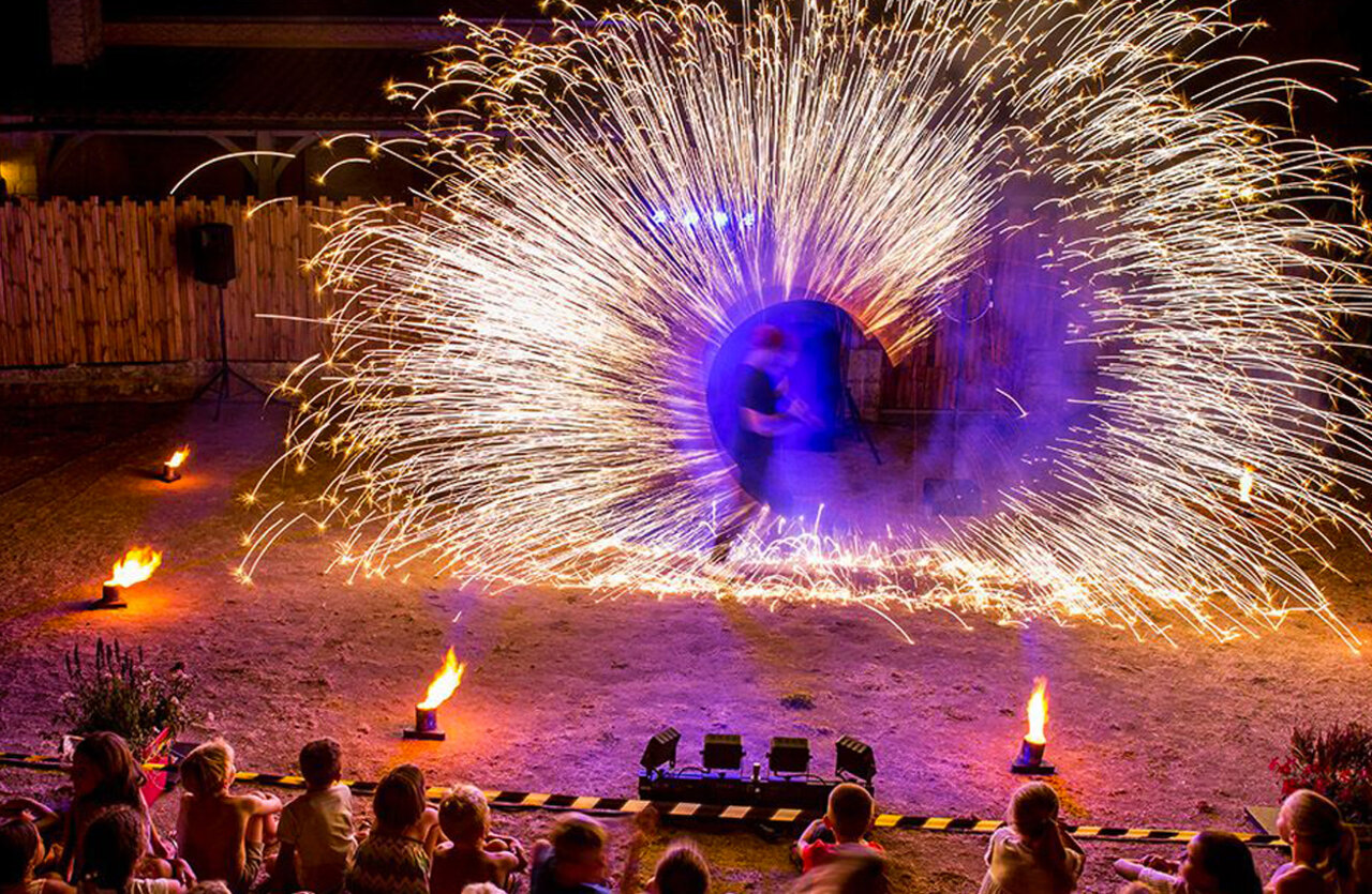 Fire show, sparks, children, at VAGUES OCEANES Granges campsite in GROLEJAC (24).