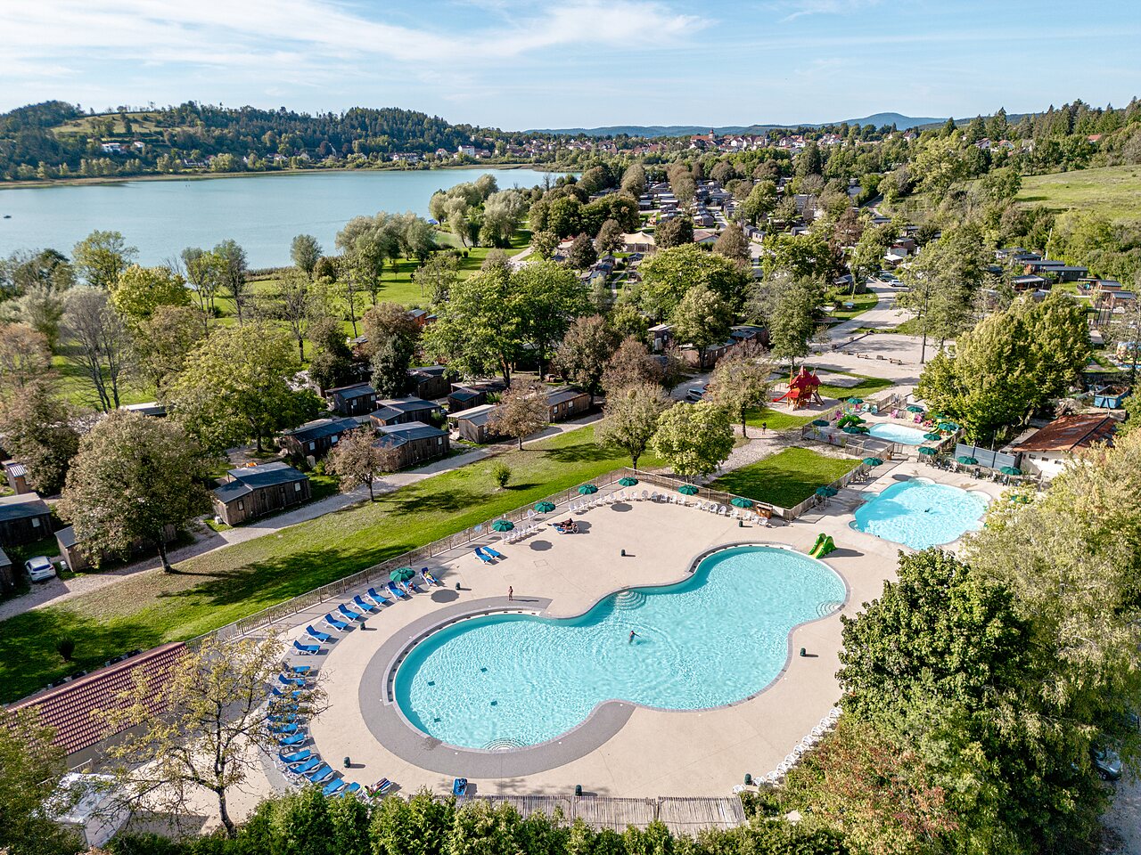 Luftaufnahme Wasserpark und Unterk�nfte auf Camping CLICOCHIC Grisi�re in Clairvaux-les-Lacs (39).