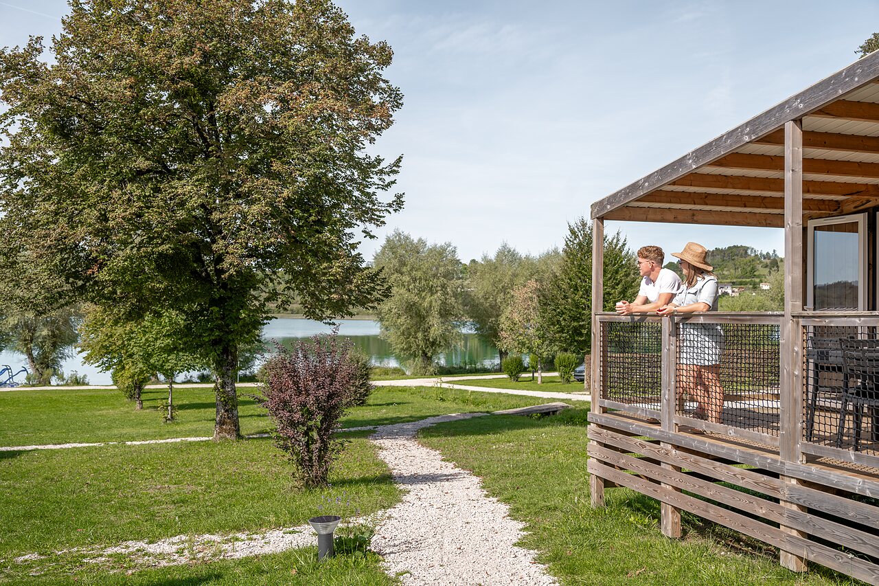 Paar auf Mobilheim-Terrasse, Seeblick, Camping CLICOCHIC Grisi�re, Clairvaux-les-Lacs.