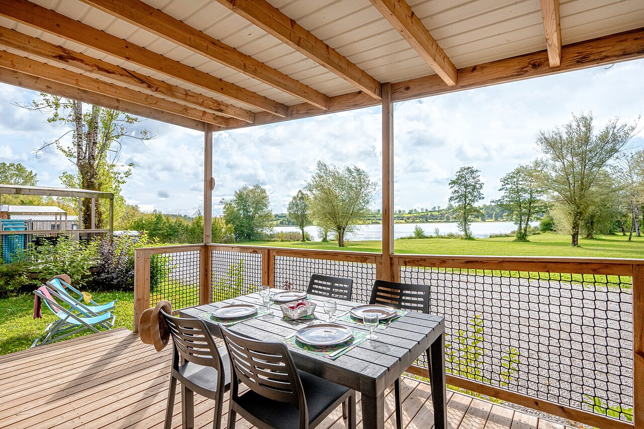 Terrasse Unterkunft, gedeckter Tisch, Seeblick auf dem Campingplatz CLICOCHIC Grisi�re in Clairvaux-les-Lacs.