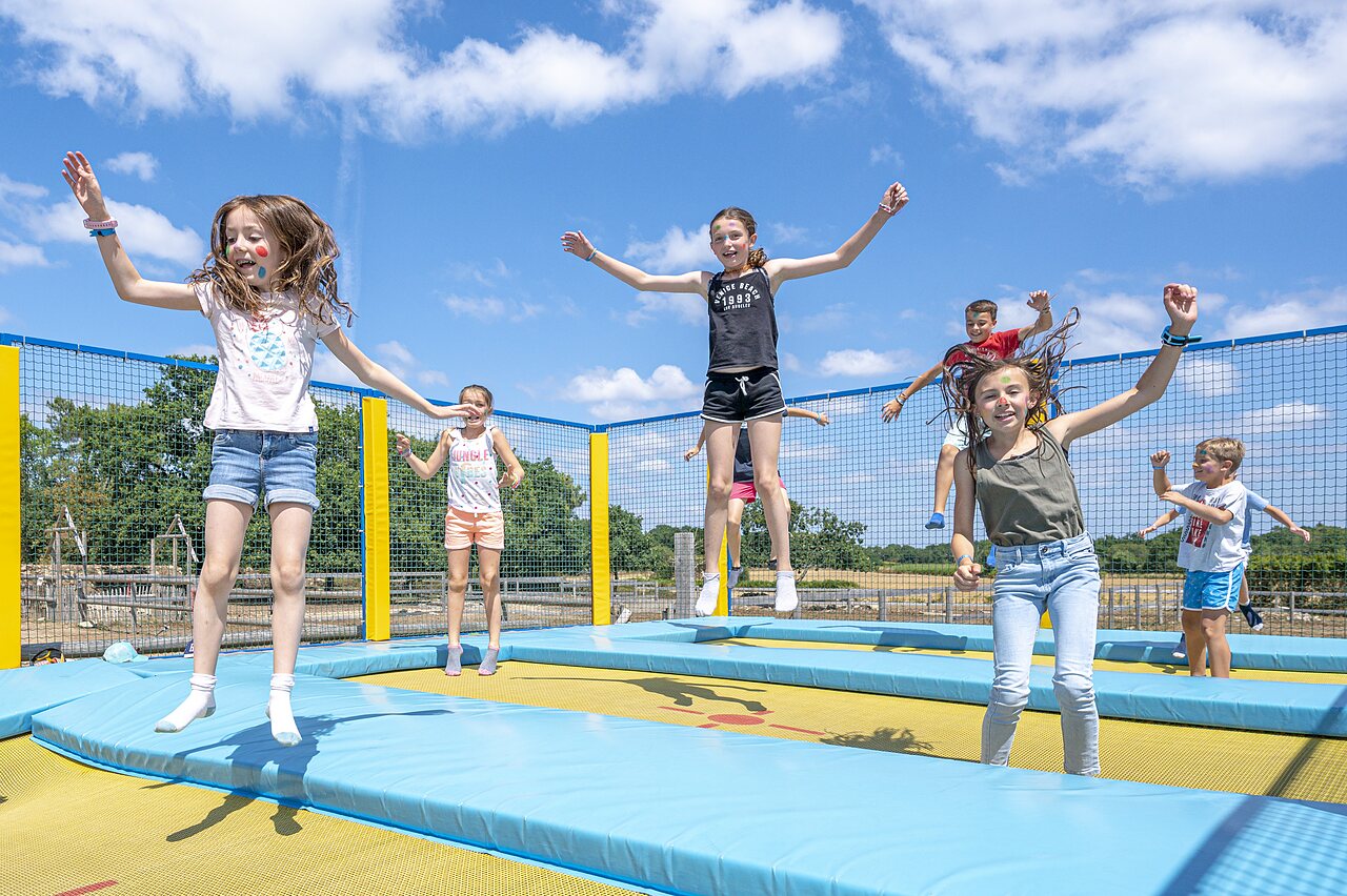 Fr�hliche Kinder springen auf den Trampolinen des Spielplatzes auf dem Campingplatz CLICOCHIC Grisi�re in Clairvaux-les-Lacs (39).