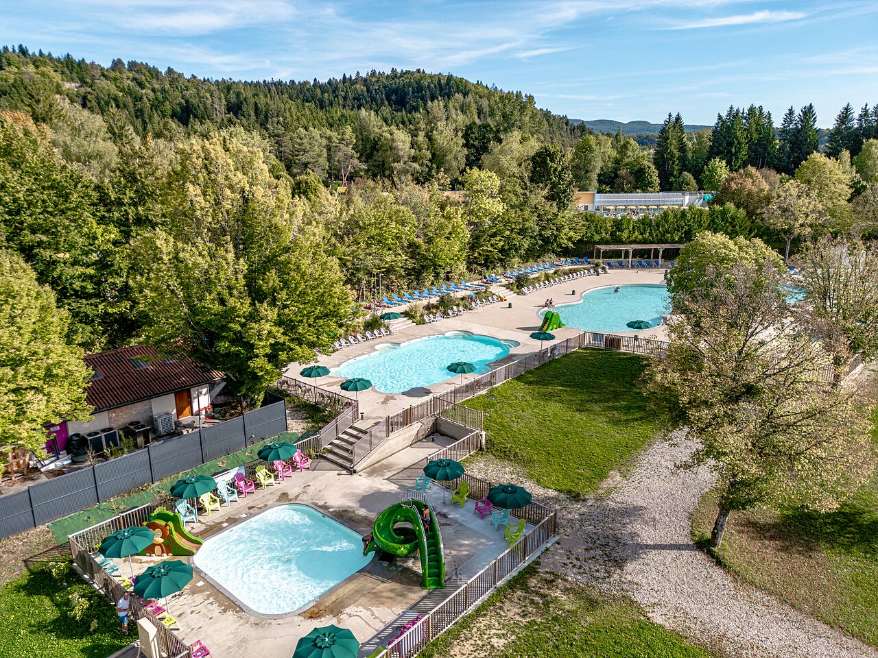 Au�enpools mit Wasserrutschen und Liegest�hlen am Campingplatz CLICOCHIC Grisi�re in Clairvaux-les-Lacs (39).