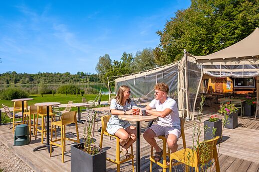 Terras van de bar-restaurant met stel en meer op CLICOCHIC Grisière.