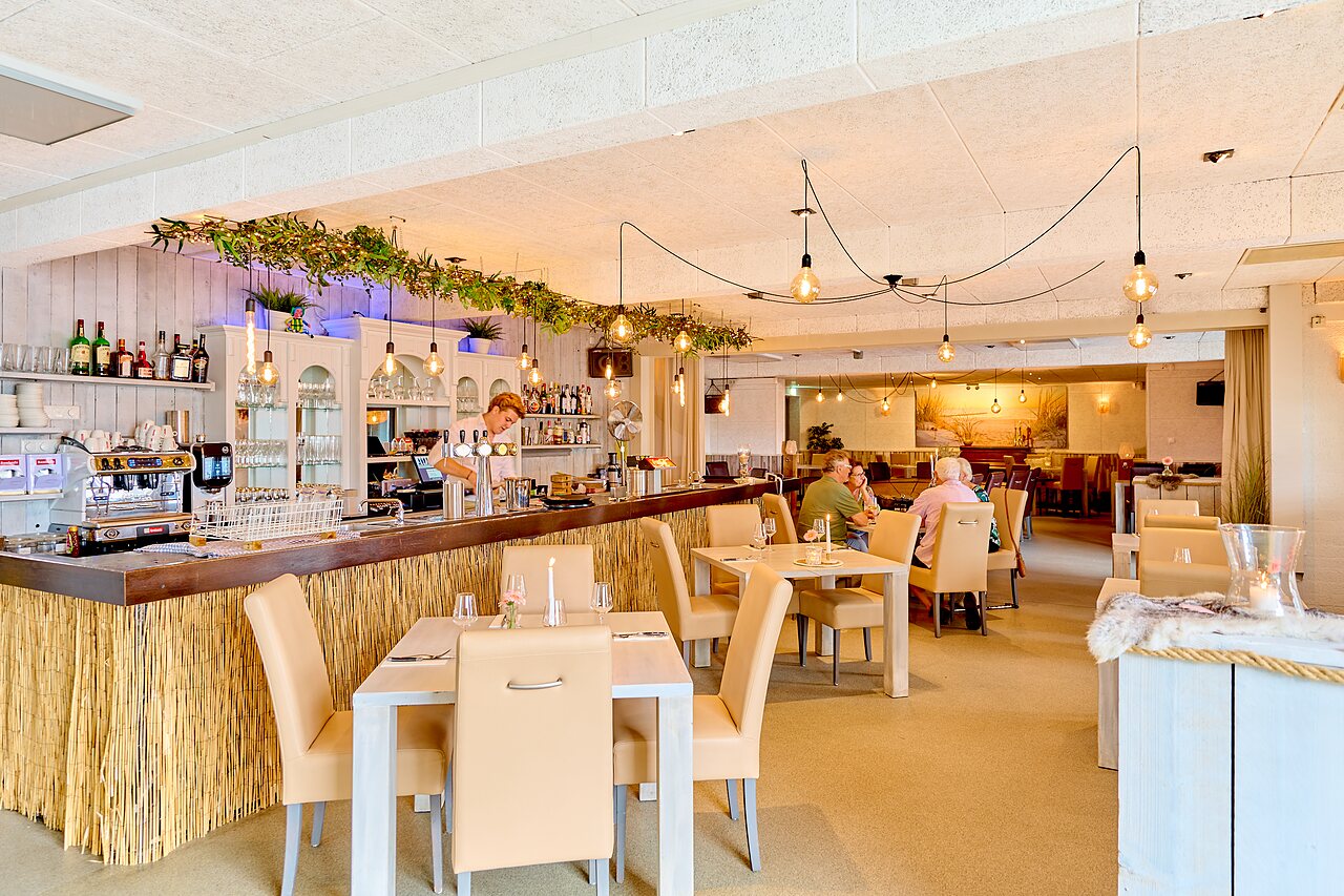 Modernes Restaurant und Bar mit Tischen auf dem Campingplatz CAPFUN Groene Eiland in Appeltern.