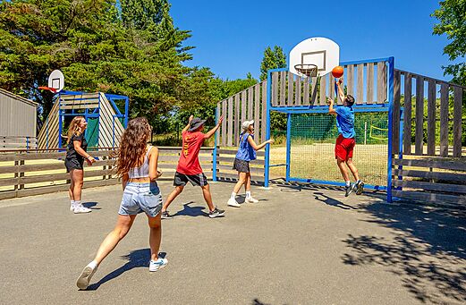 Jugendliche spielen Basketball auf dem Multisportplatz des Campingplatzes VAGUES OCEANES Grosses Pierres in Saint-Georges-d'Ol�ron.