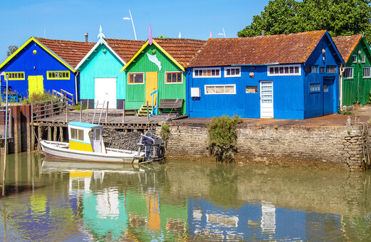 Bunte Austernhütten und Fischerboot in einem typischen Dorf in Charente-Maritime.