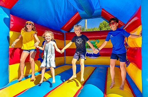Fr�hliche Kinder springen in einer farbenfrohen H�pfburg auf dem Campingplatz VAGUES OCEANES Grosses Pierres in Saint-Georges-d'Ol�ron (17).