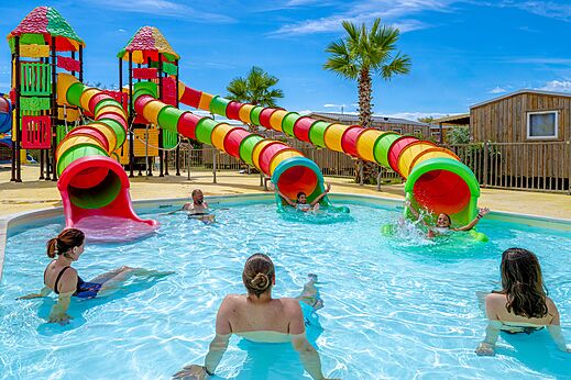 Kleurrijke waterglijbanen en familiezwembad op camping VAGUES OCEANES Hamacs à Fleury (11).