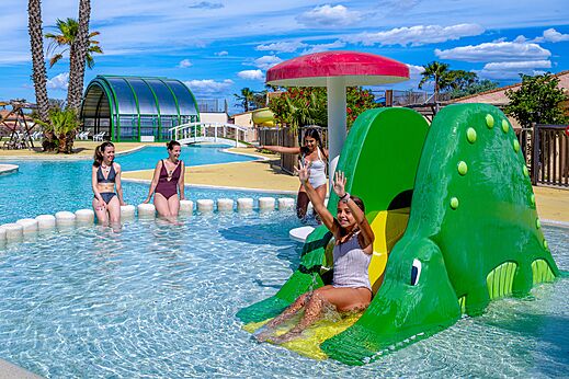Krokodillenglijbaan en buitenzwembad met kinderen op camping VAGUES OCEANES Hamacs in Fleury (11).