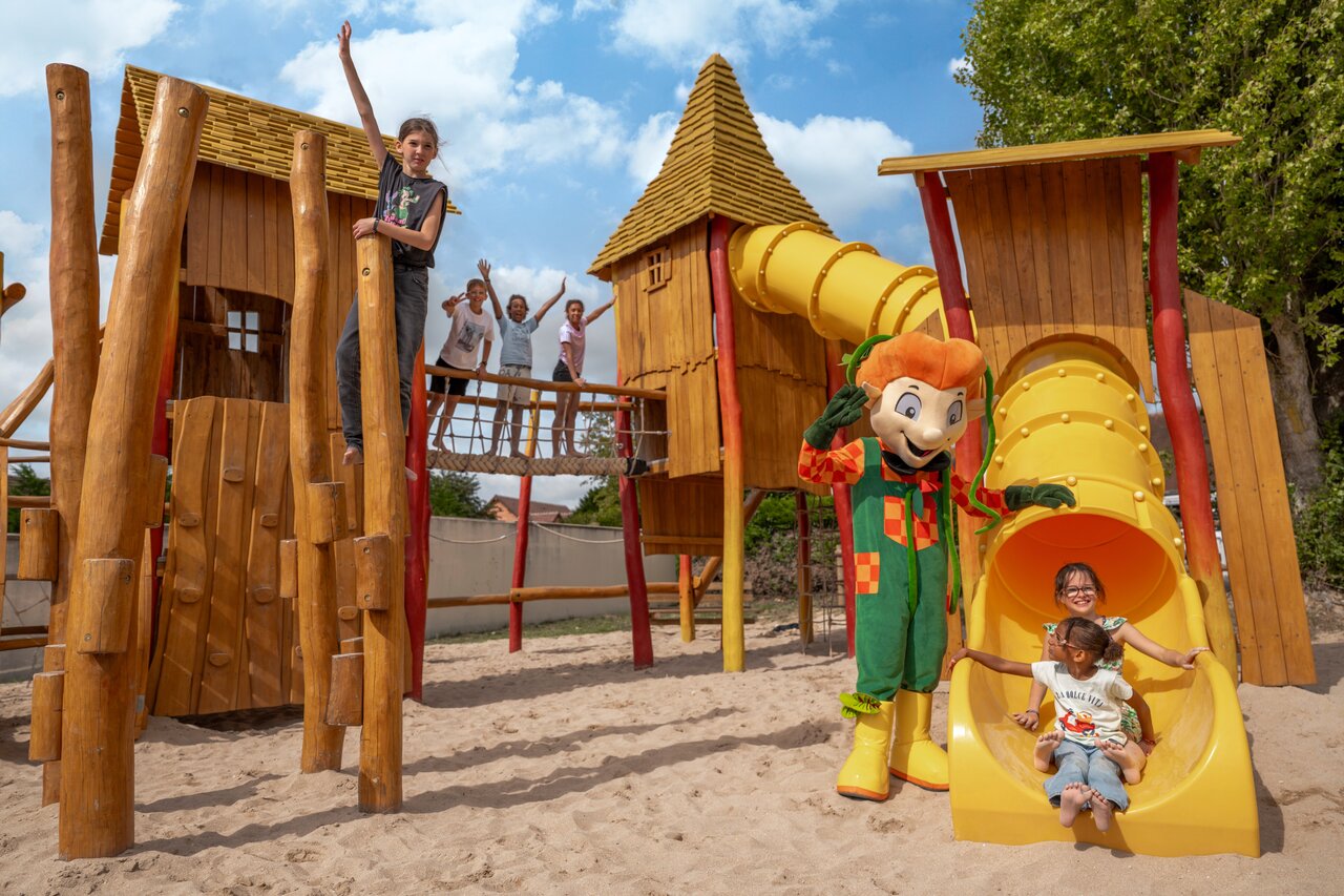 Holzspielplatz, Rutschen, Kinder und Maskottchen auf Camping CLICOCHIC Haras de Deauville.