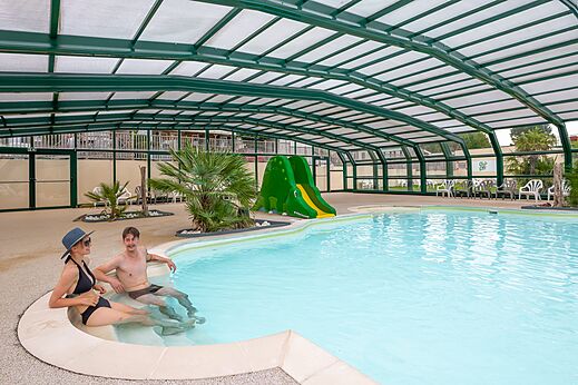 Hallenbad, Wasserrutsche und Paar auf dem Campingplatz CLICOCHIC Haras de Deauville.