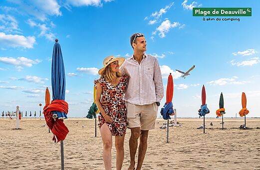 Strand van Deauville met kleurrijke parasols en stel, bezienswaardigheid in Normandi�.