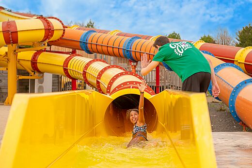 Kind auf gelber Wasserrutsche, Animateur, Camping CLICOCHIC Haras de Deauville (14).