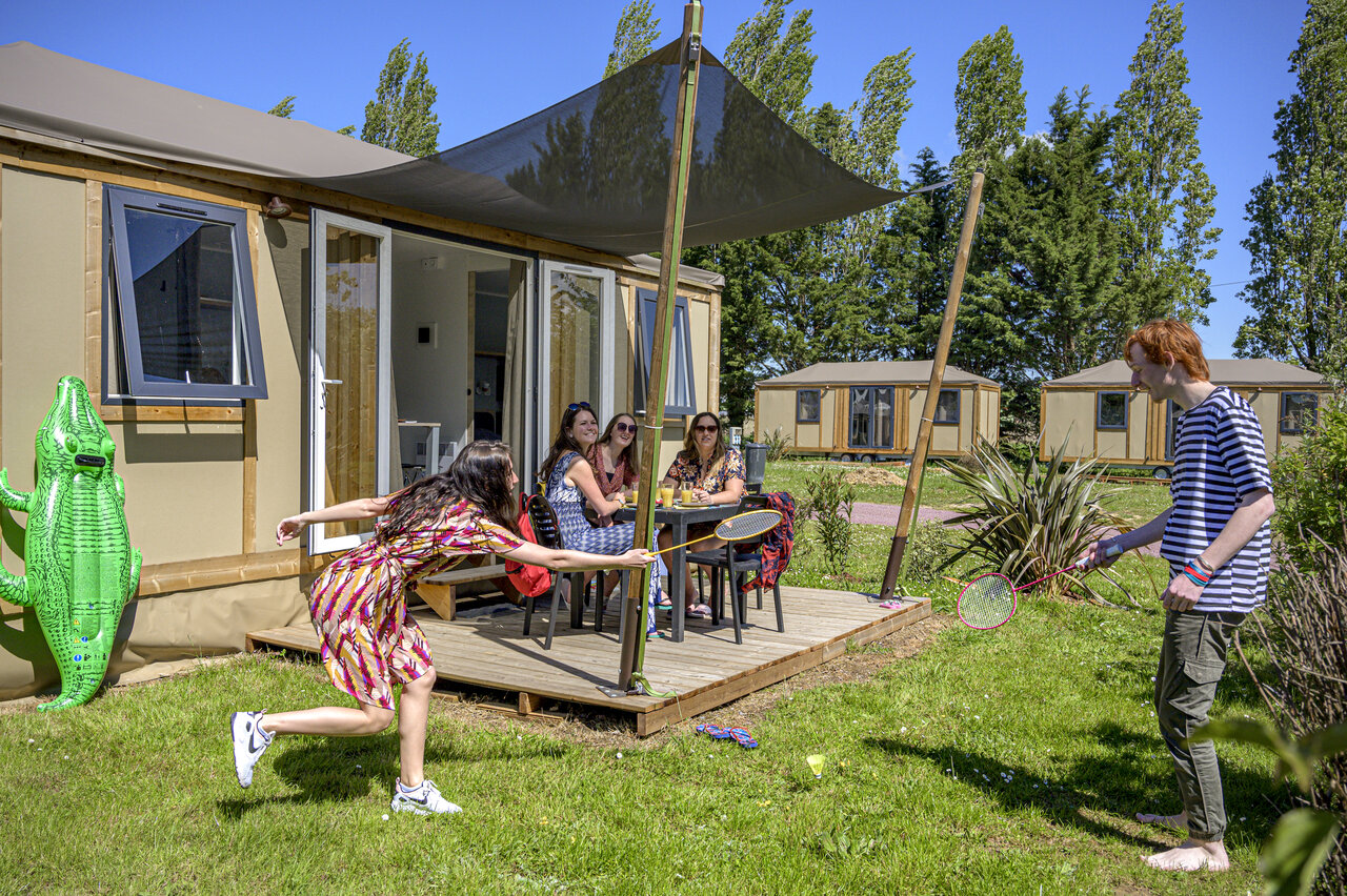 Familie spielt Badminton vor Glamping-Unterkunft, Terrasse, auf CAPFUN Hautes Coutures BENOUVILLE (14).