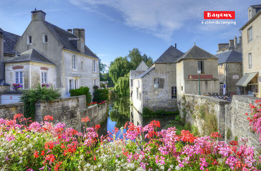Historische Stadt Bayeux mit blühendem Kanal und alten Häusern in der Normandie.