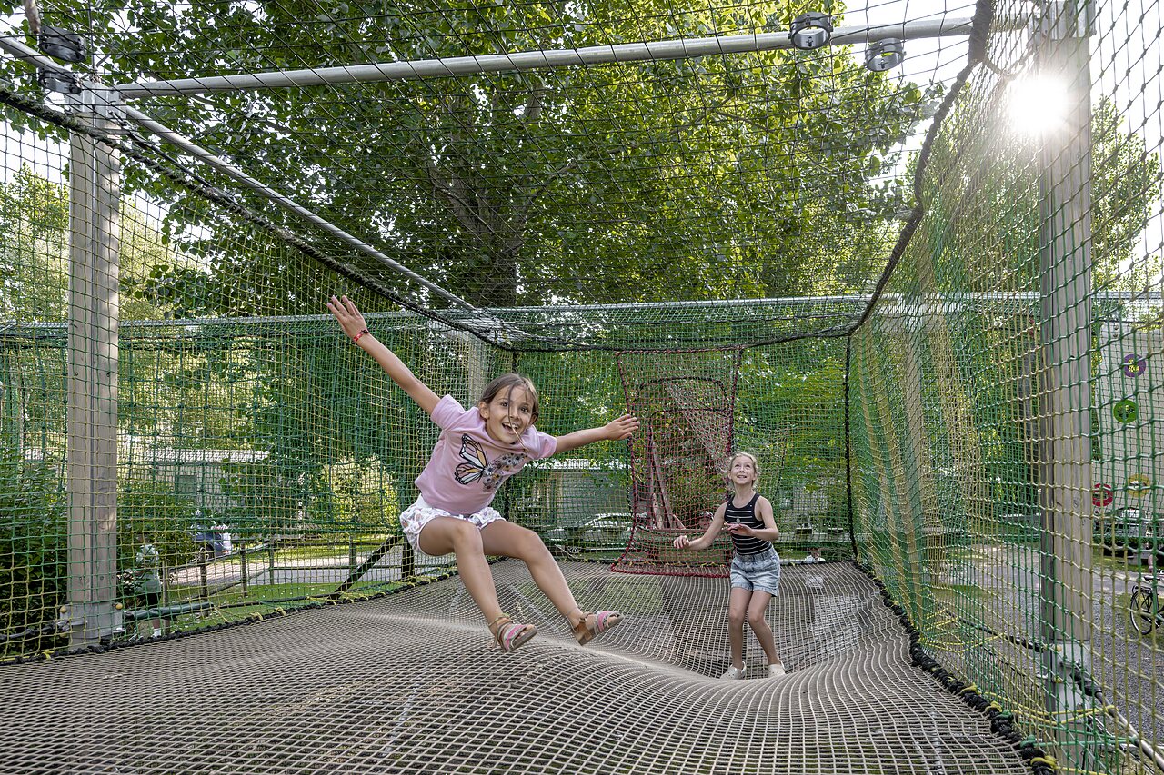 Kinder spielen auf einem riesigen Netztrampolin auf dem Campingplatz CLICOCHIC Havre de Berni�res.