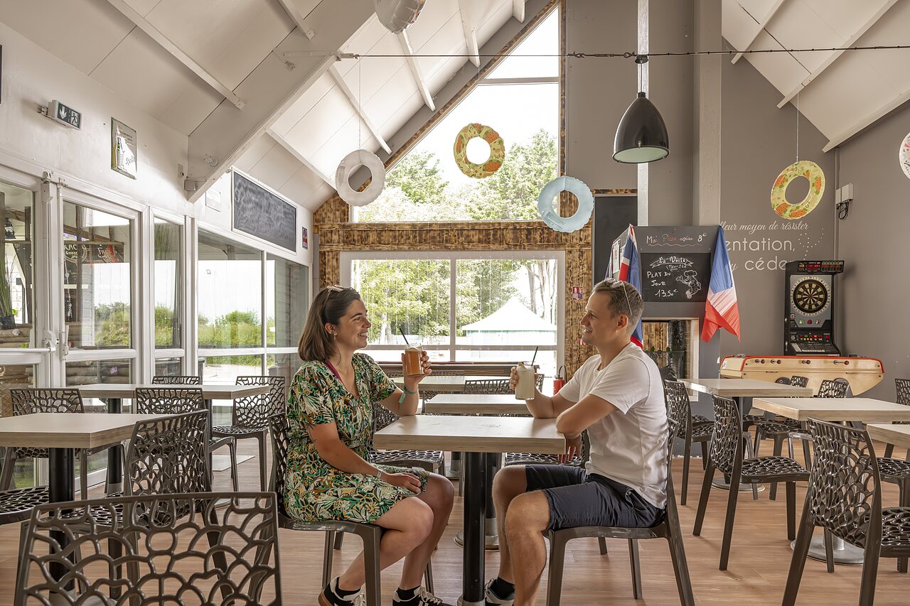 L�chelndes Paar trinkt etwas an der Bar des Campingplatzes CLICOCHIC Havre de Berni�res.