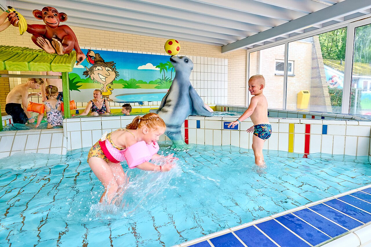 Hallenbad mit Wasserspielen und Kindern auf dem Campingplatz CAPFUN Heino in Heino.