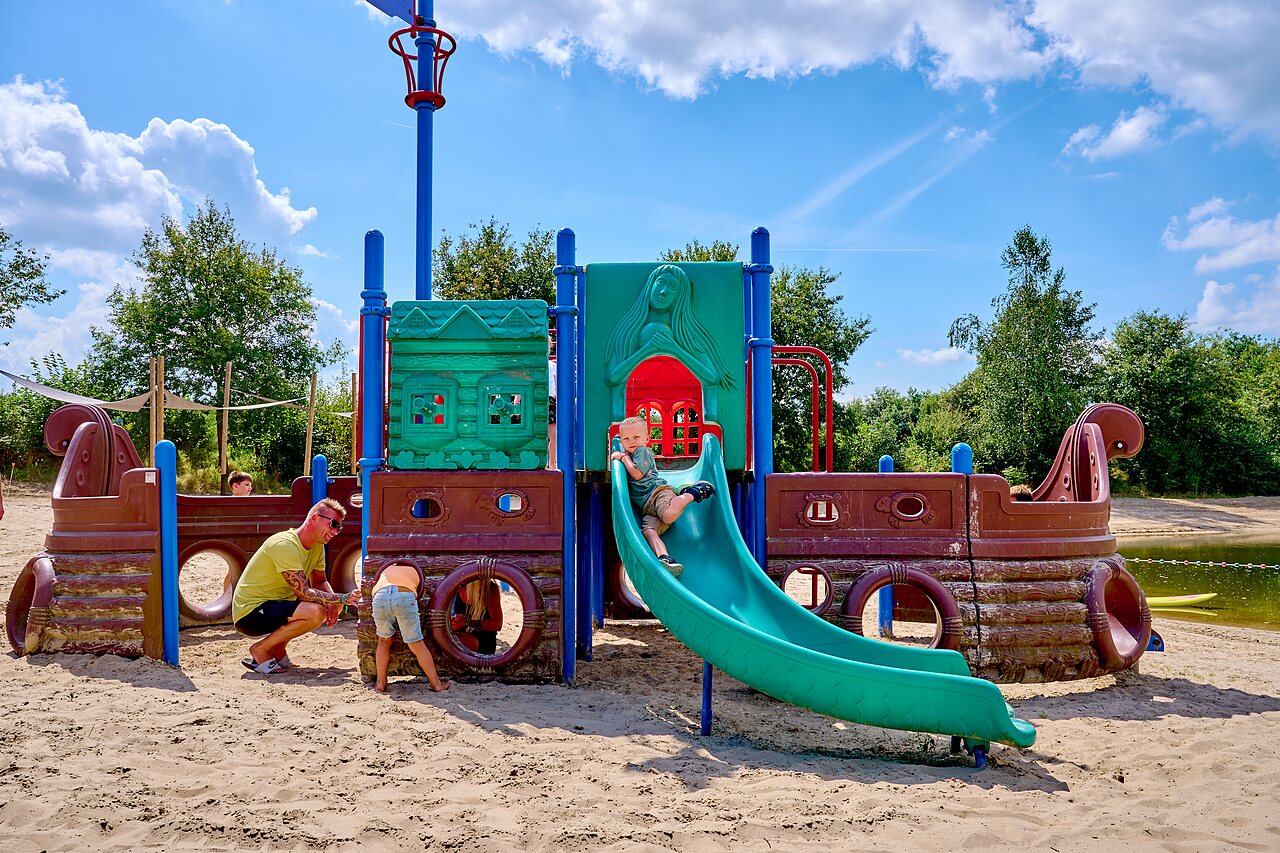 Kinder spielen auf Piraten-Spielplatz mit Rutsche auf Campingplatz CAPFUN Heino.