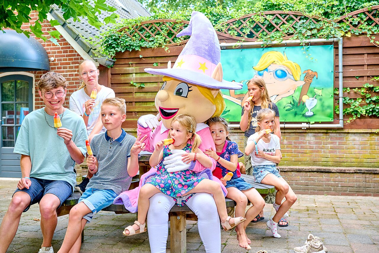 Maskottchen und lachende Kinder essen Eis am Camping CAPFUN Heino in Heino.