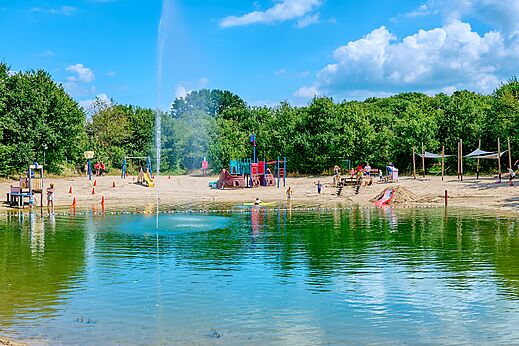 Sandstrand mit Kinderspielplätzen und Naturbadeteich auf dem Campingplatz CAPFUN Heino in Heino.