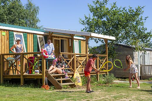 Familie genießt Mobilheim mit Terrasse auf dem Campingplatz CAPFUN Heino in Heino.