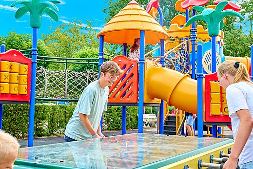 Colorful playground with slides and foosball table at CAPFUN Heino campsite in Heino.