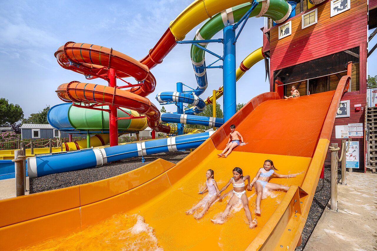Colorful water slides and children having fun at CAPFUN Hermitage campsite in SERIGNAN (34).