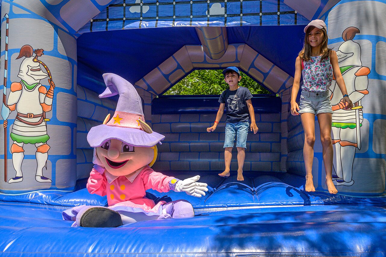 Bouncy castle with children and mascot at CAPFUN Hermitage campsite in SERIGNAN (34).