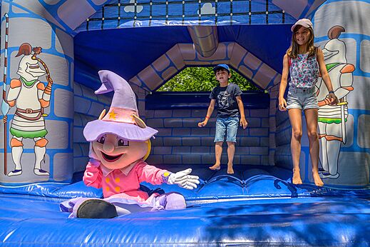 Hüpfburg mit Kindern und Maskottchen auf dem Campingplatz CAPFUN Hermitage in SERIGNAN (34).