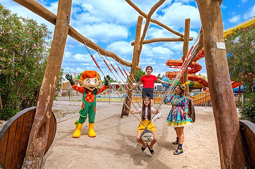 Speeltuin met schommel, kinderen, mascotte en animatrice op camping CAPFUN Hermitage in SERIGNAN (34).