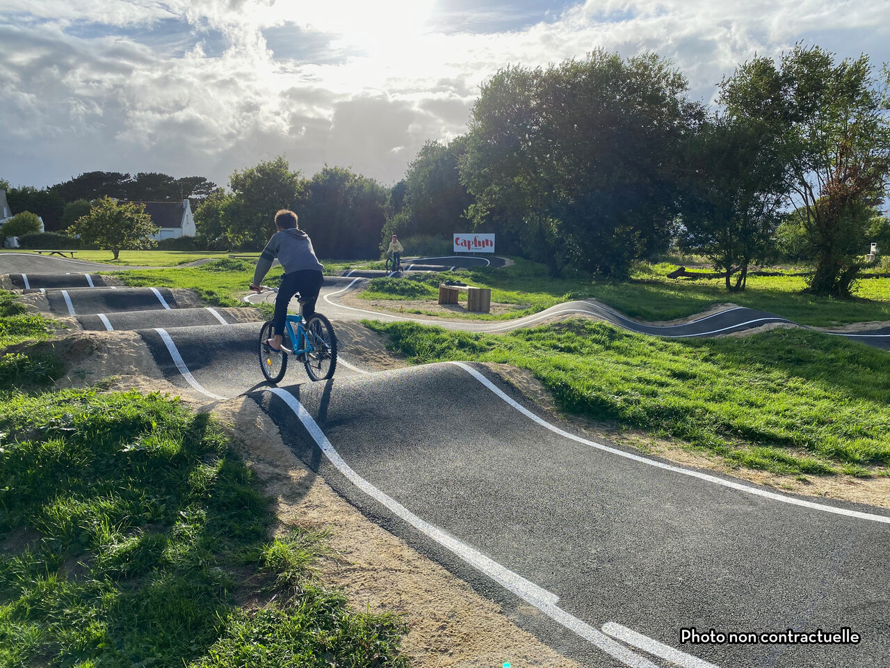 Kind auf Fahrrad auf modernem Pumptrack auf Camping CAPFUN Hirondelle in Oteppe.