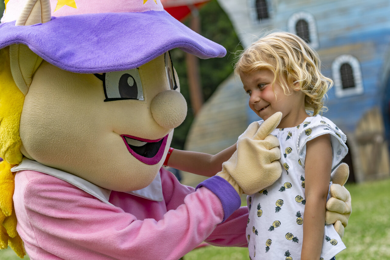 L�chelndes Kind mit Animationsmaskottchen auf dem Campingplatz CAPFUN Hirondelle in Oteppe.
