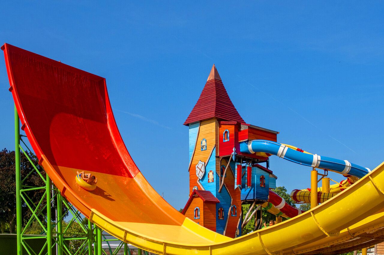 Riesige Wasserrutsche und bunter Wasserspielturm auf dem Campingplatz CAPFUN Hirondelle in Oteppe.