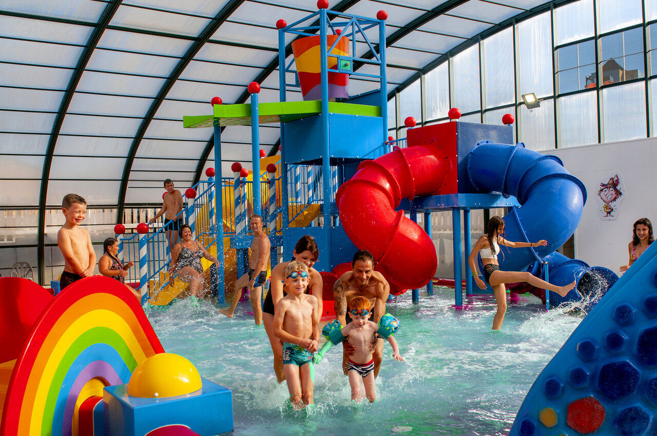 �berdachter Wasserpark mit bunten Rutschen und Wasserspielen auf dem Campingplatz CAPFUN Hirondelle in Oteppe.
