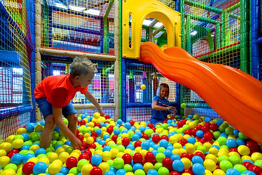 Kinder spielen in farbenfrohem B�llebad mit Rutsche auf Campingplatz CAPFUN Hirondelle in Oteppe.