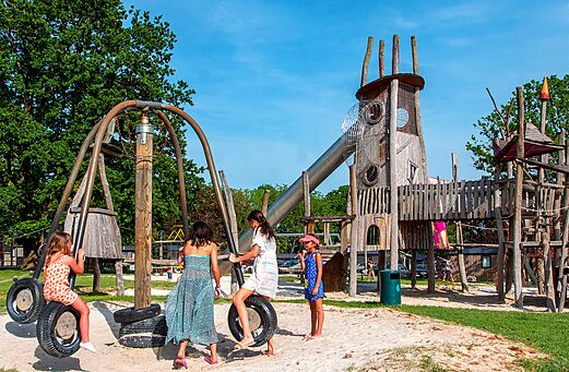 Großer Holzspielplatz mit Rutsche und Schaukeln auf dem Campingplatz CAPFUN Hirondelle in Oteppe.